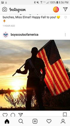 a man holding an american flag in front of the sun