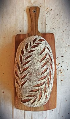 a wooden cutting board topped with a loaf of bread