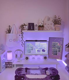 a desk with a computer, keyboard and mouse on it in front of a purple wall