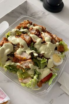 a salad in a plastic container with dressing on top