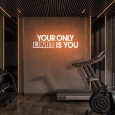 there is a neon sign that says your only limit is you on the wall next to an exercise bike