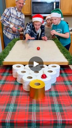 a group of people standing around a table with rolls of toilet paper on top of it