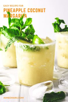 pineapple coconut margarita with mint garnish in glasses on a white wooden table