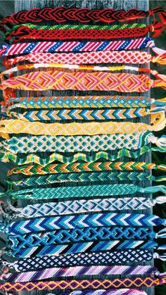 many different colored bracelets are stacked on top of each other