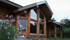 a log home with flowers in front of it