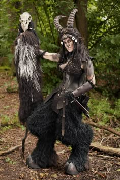 two people dressed up as horned creatures in the woods