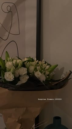 a bouquet of white flowers sitting on top of a brown paper bag