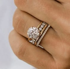 a woman's hand with two rings on it and a diamond in the middle