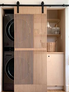 a washer and dryer in a room with wooden slats on the doors