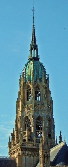 an old building with a steeple and clock on it's side against a blue sky