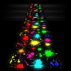 a long line of colorful paint splattered on the floor in front of a black background