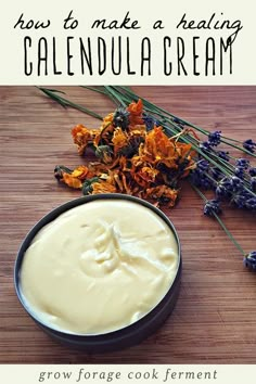 a bowl of cream next to some flowers on a table with the words how to make a healthy calendula cream