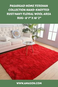 a living room with a red rug on the floor and a white couch in front of it