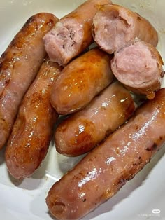 several sausages in a white bowl on a table