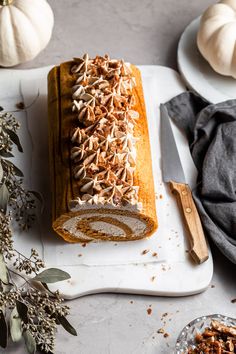 a loaf of pumpkin spice bread on a cutting board next to two bowls of nuts