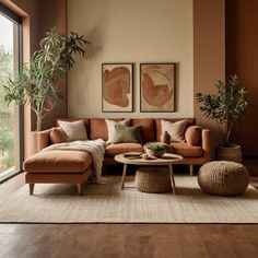 a living room filled with lots of furniture and plants on top of a wooden floor