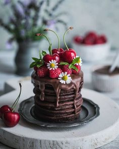 a chocolate cake topped with cherries and fresh berries