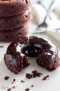 a chocolate doughnut with one bite taken out of it