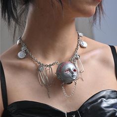 "At an old craft fair, there was a young woman named Ellie who had a penchant for nostalgic crafts. One day, she found an unusual necklace called \"Y2K 2002 Handmade Necklace\". The necklace was so unusual that she couldn't help but want to know the story behind it. The pendant of the necklace was a small human head doll, and its eyes were what made it so special. Ellie looked closely and realized that the left and right eyes were very different. One eye was filled with red color and had no eyeballs, as if it was a bottomless abyss of red, while the other eye was filled with several white beads of different sizes, like bright stars in a starry sky. Ellie was fascinated by the unique pair of eyes, which seemed to her to speak of contrast, symbolizing the light and darkness of life, hope and Harajuku Style Handmade Jewelry For Parties, Handmade Harajuku Jewelry For Party, Unique Handmade Necklaces For Cosplay, Unique Handmade Necklace For Cosplay, Harajuku Style Handmade Party Necklaces, Handmade Punk Necklaces For Cosplay, Handmade Gothic Necklace, Handmade Silver Gothic Chain Necklace, Eyeball Jewelry