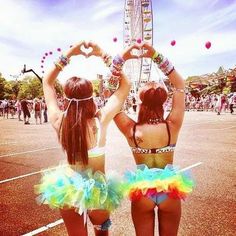 two girls standing in front of a ferris wheel