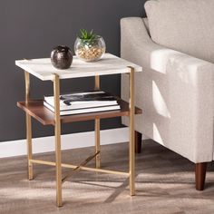 a small table with a plant on it next to a couch in a living room