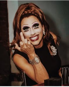 a woman with makeup on her face posing for the camera