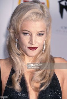 a woman with long blonde hair and red lipstick on the red carpet at an event