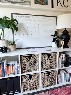 a white shelf with baskets and books on it