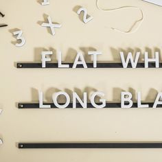 the words flat white and long black are arranged on top of a table with scissors