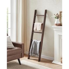 a ladder leaning up against a wall next to a chair and fireplace in a living room