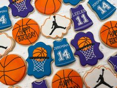 decorated cookies with basketballs and jerseys are displayed on a white tablecloth in this image