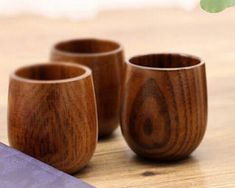 three wooden cups sitting on top of a table