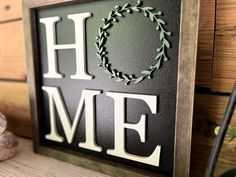 a sign that says home with a wreath on it