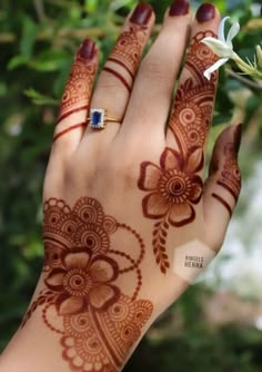 a woman's hand with henna on it and a flower in the middle