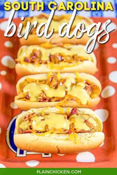 three hot dogs with cheese and bacon on them sitting in a red tray that says south carolina bird dogs