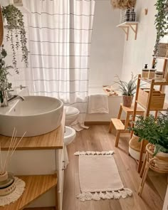 a bathroom with wooden floors and plants in the window sill next to the bathtub