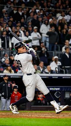 a baseball player holding a bat on top of a field in front of a crowd