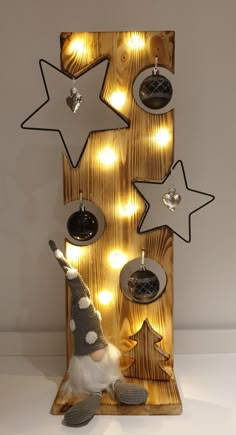 a wooden sign with christmas decorations and lights on the front, hanging from it's sides