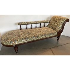 an antique style chaise lounge with floral upholstered fabric and wood feet rest