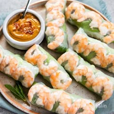 shrimp rolls on a plate with dipping sauce