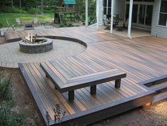 a wooden deck with benches and fire pit