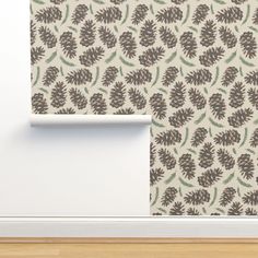 a white wall with a brown and green flower pattern on it next to a wooden floor