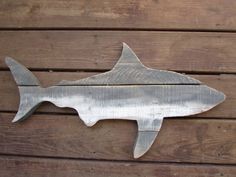 a metal fish on a wooden wall