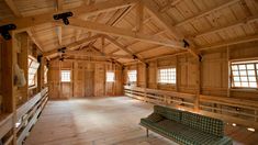 an empty room with wood paneling and wooden benches in the center, surrounded by windows