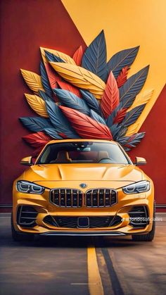 a yellow sports car parked in front of a wall with colorful leaves on it's side