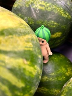 there is a small figurine on top of some watermelons