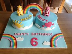 two birthday cakes with teddy bears and rainbows