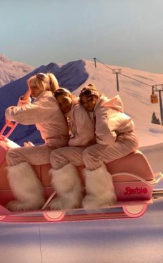 three people riding in a pink sleigh with fur on the front and back