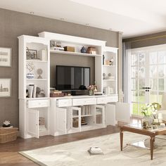 a living room filled with furniture and a flat screen tv on top of a white entertainment center