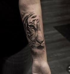 a hand with a tiger tattoo on it's left arm and the wrist is shown